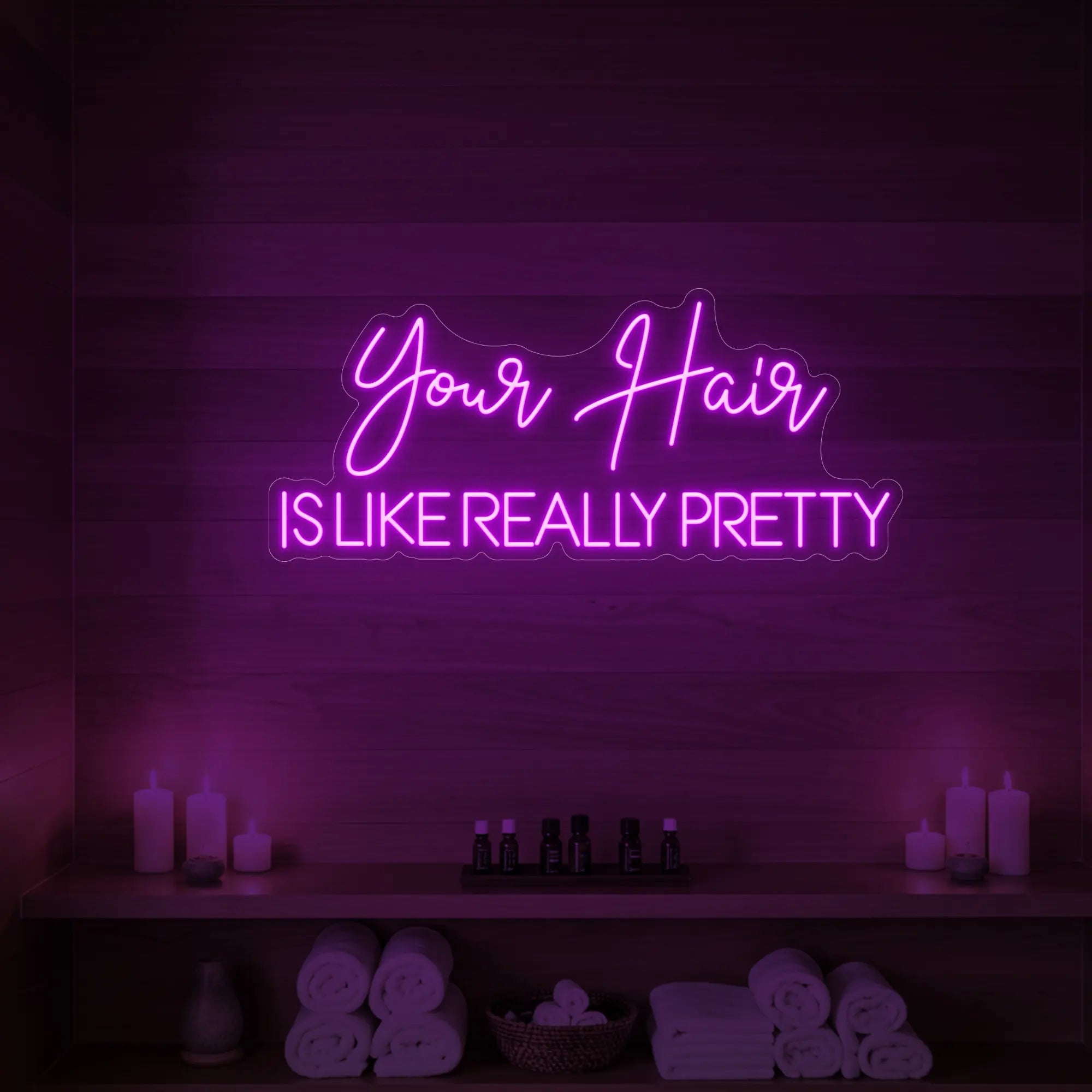 Photo of the 'Your Hair Is Like Really Pretty' neon sign glowing in deep pink against a styled interior wall.