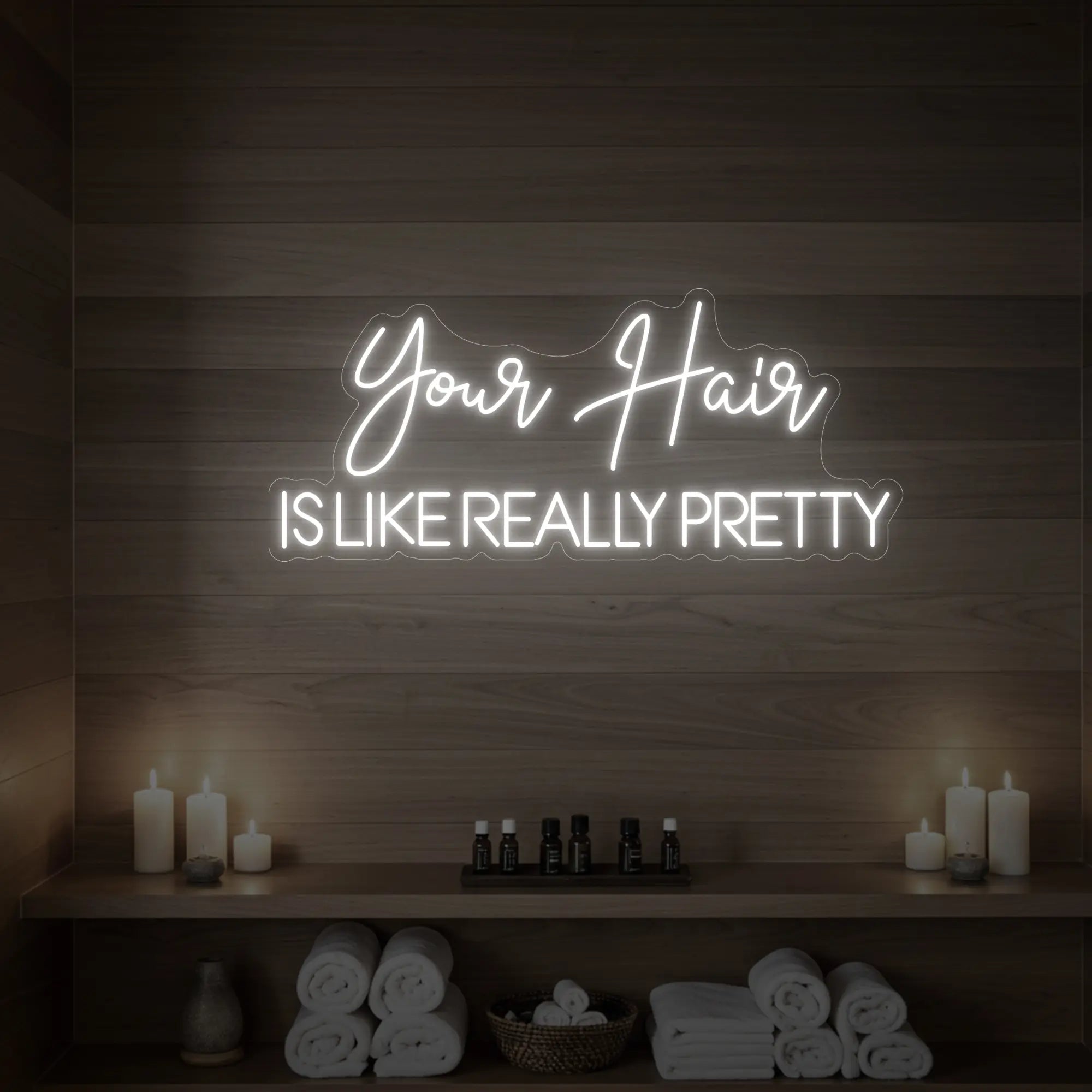 Photo of the 'Your Hair Is Like Really Pretty' neon sign glowing in cool white against a styled interior wall.