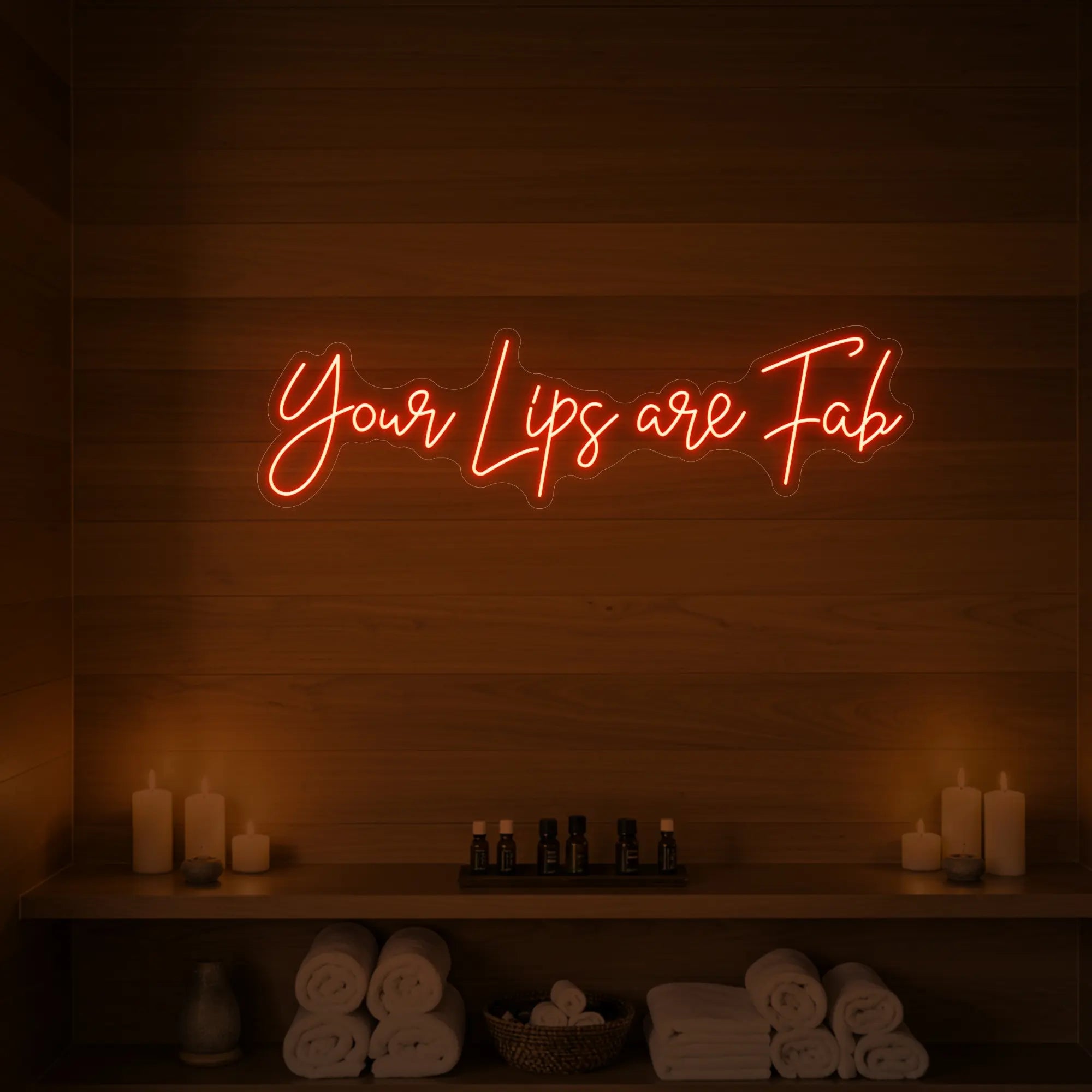 Photo of the 'Your Lips Are Fab' neon sign glowing in lemon yellow against a styled interior wall.