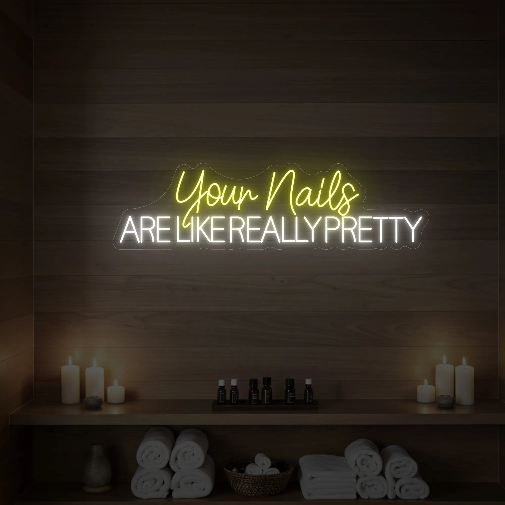 Photo of the 'Your Nails Are Like Really Pretty' neon sign glowing in lemon yellow against a styled interior wall.