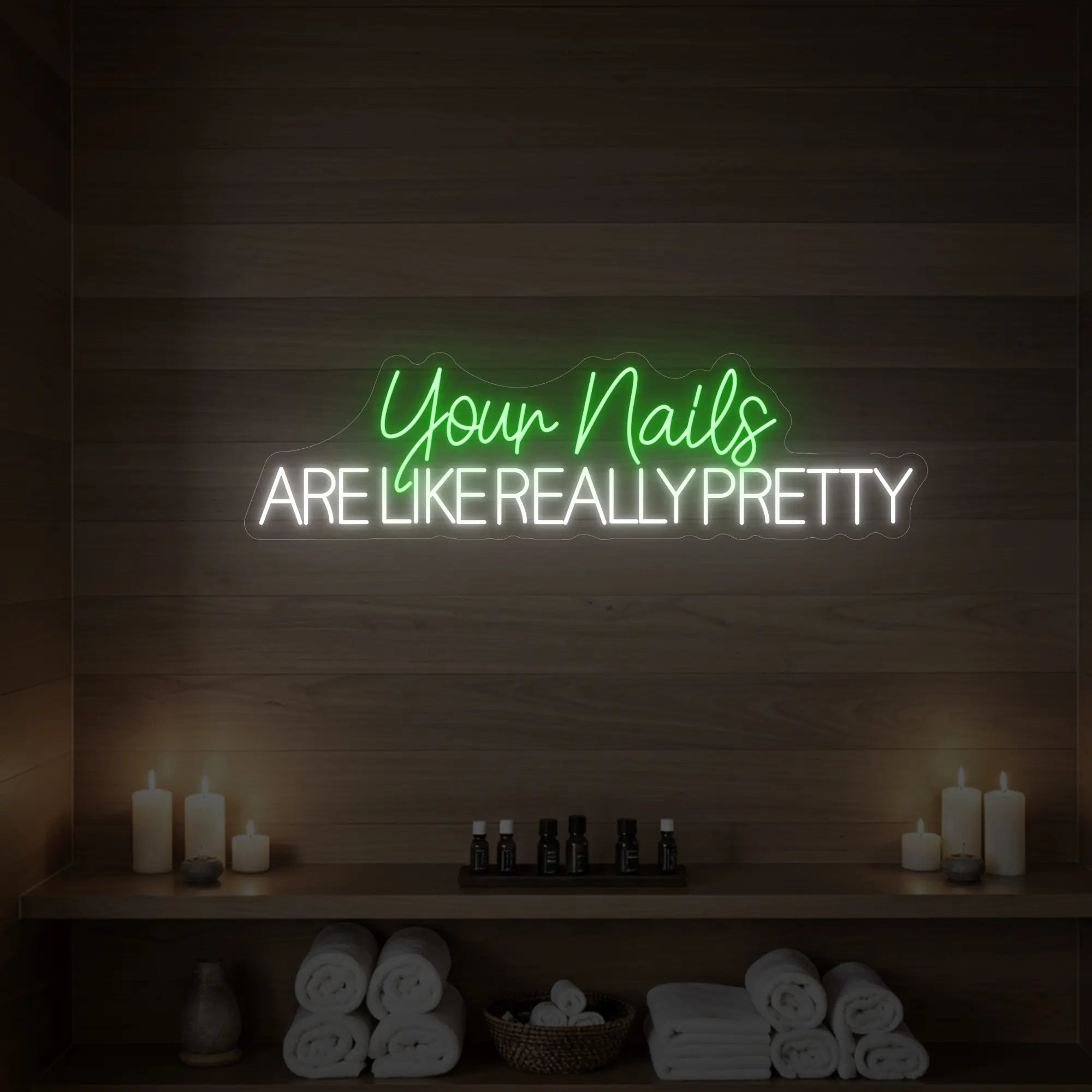 Photo of the 'Your Nails Are Like Really Pretty' neon sign glowing in green against a styled interior wall.