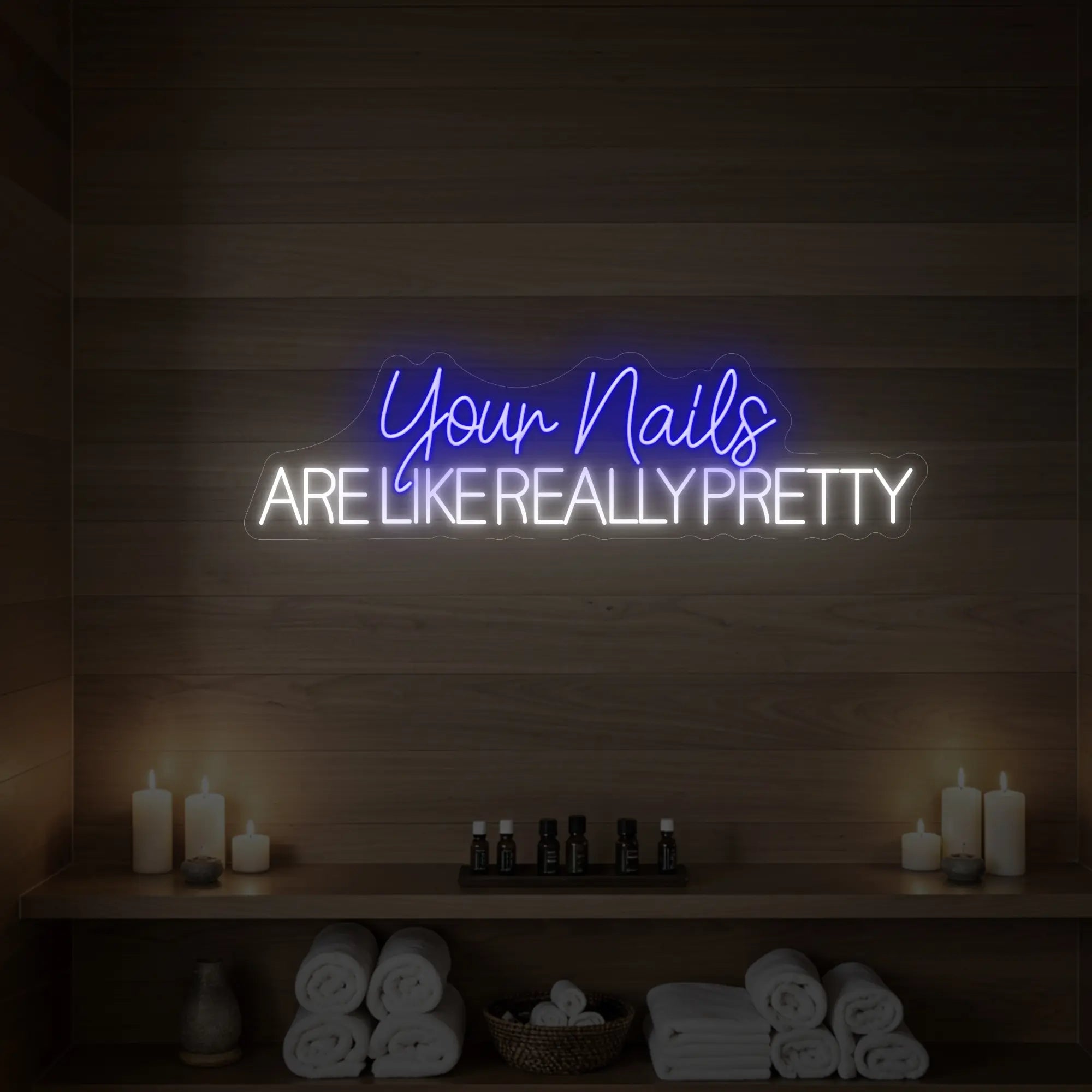 Photo of the 'Your Nails Are Like Really Pretty' neon sign glowing in deep blue against a styled interior wall.