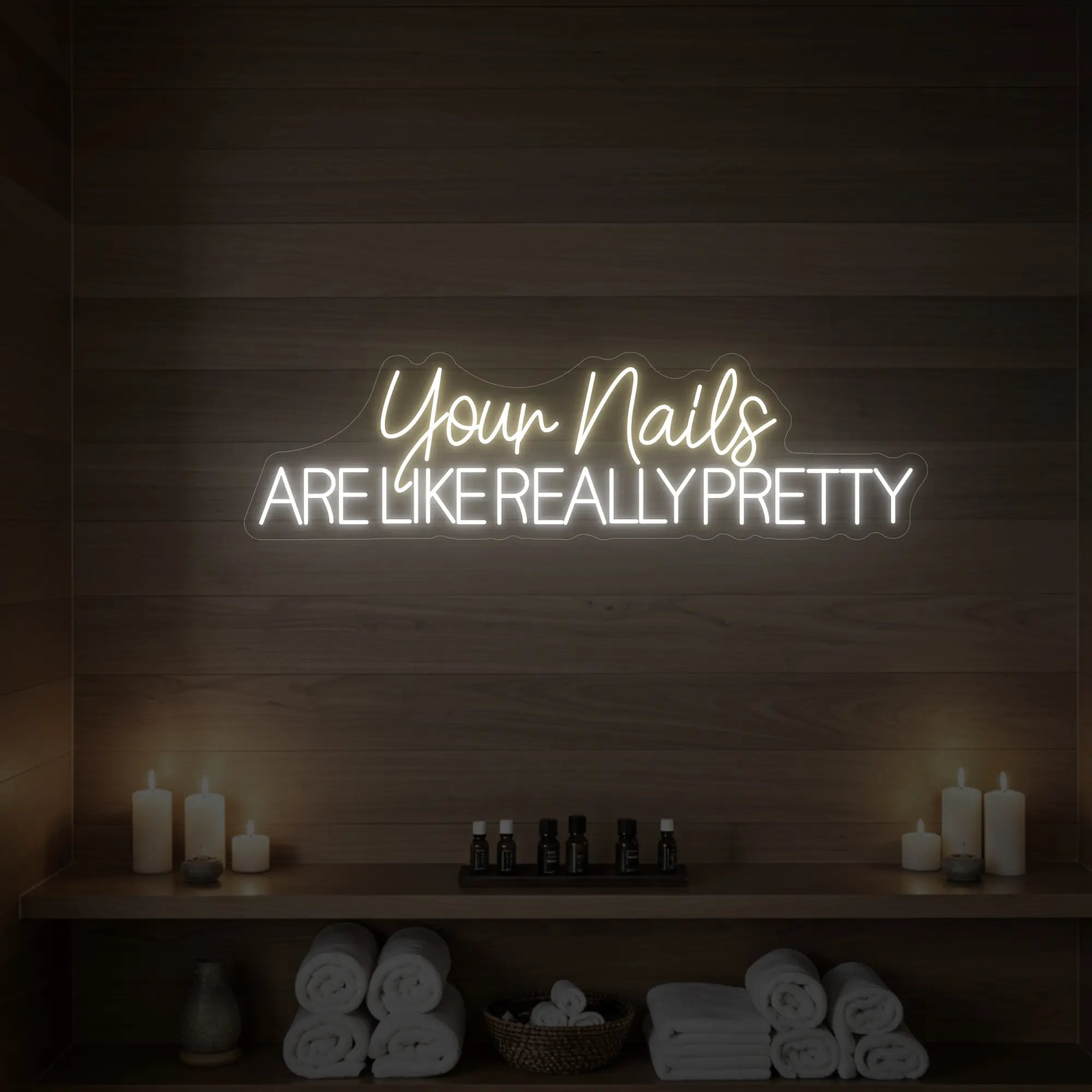 Photo of the 'Your Nails Are Like Really Pretty' neon sign glowing in warm white against a styled interior wall.