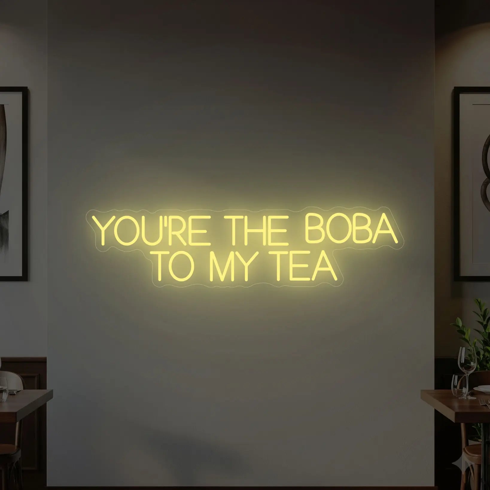Photo of the 'YOU’RE THE BOBA TO MY TEA' neon sign glowing in warm white against a styled interior wall.