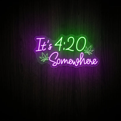 It's 4:20 Somewhere LED neon sign featuring green and purple lettering with cannabis leaf accents on a clear acrylic backing.