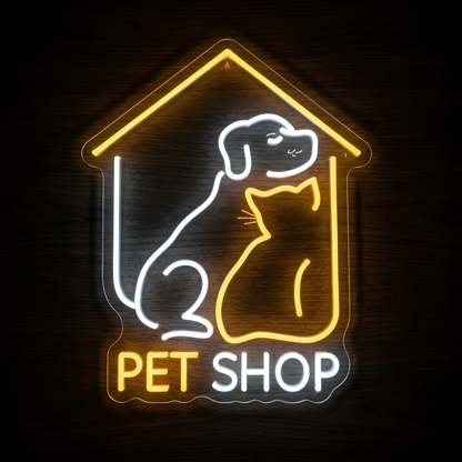 Home Pet Shop LED Neon Sign featuring a white dog and warm yellow cat sitting inside a glowing house outline with Pet Shop lettering, displayed on clear acrylic against a dark wood wall for pet stores, animal boutiques, and pet care businesses.