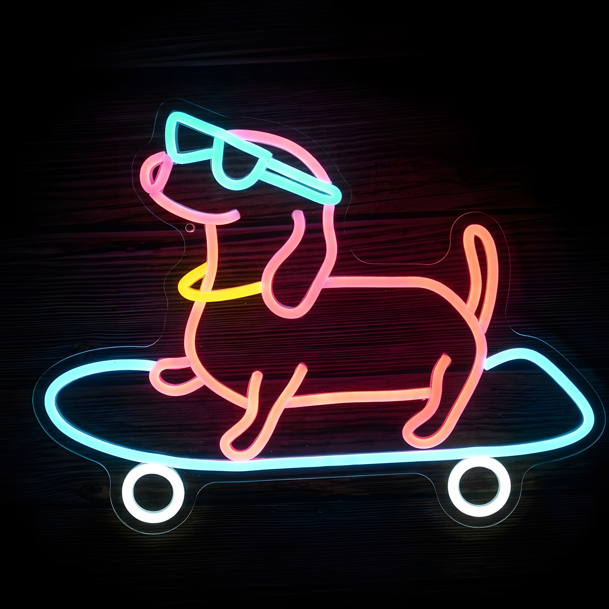 Skateboarding Dog LED Neon Sign featuring a playful pink neon dog wearing bright blue sunglasses and riding a blue skateboard with glowing white wheels on clear acrylic backing against a dark wood wall.