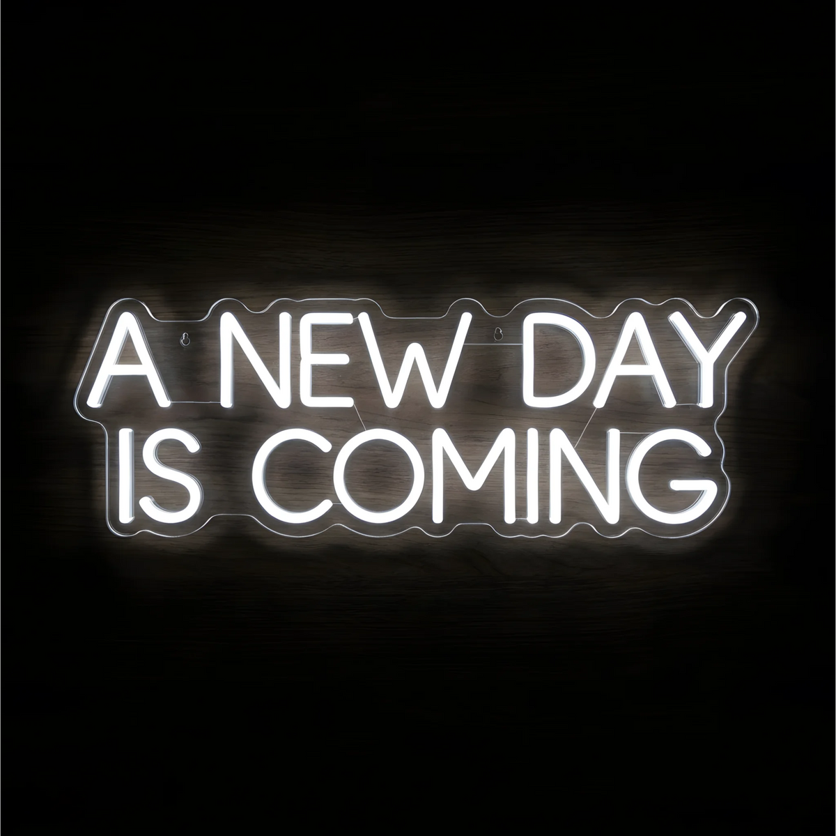 “A NEW DAY IS COMING” LED Neon Sign glowing in bright white uppercase letters across two lines on clear acrylic against a dark wood background, suited to bedrooms and home offices.
