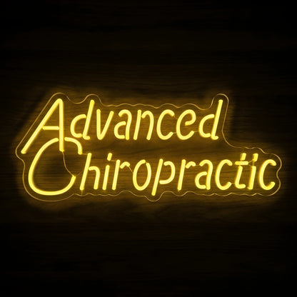 Advanced Chiropractic LED neon sign with golden-yellow script lettering on clear acrylic backing for chiropractic office and medical clinic wall decor.