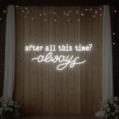 Photo of the 'After All This Time V1' neon sign glowing in cool white against a styled interior wall.