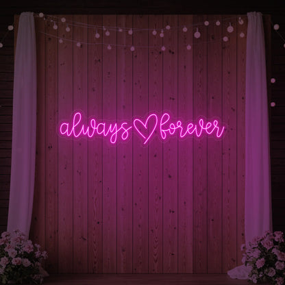 Photo of the 'Always Heart Forever' neon sign glowing in light pink against a styled interior wall.