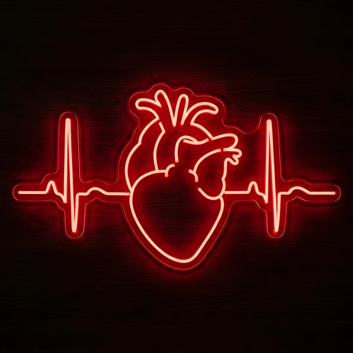 Anatomical Heart ECG LED Neon Sign featuring a glowing red anatomical human heart with an electrocardiogram heartbeat line extending on both sides, mounted on clear cut-to-shape acrylic against a dark wooden wall.