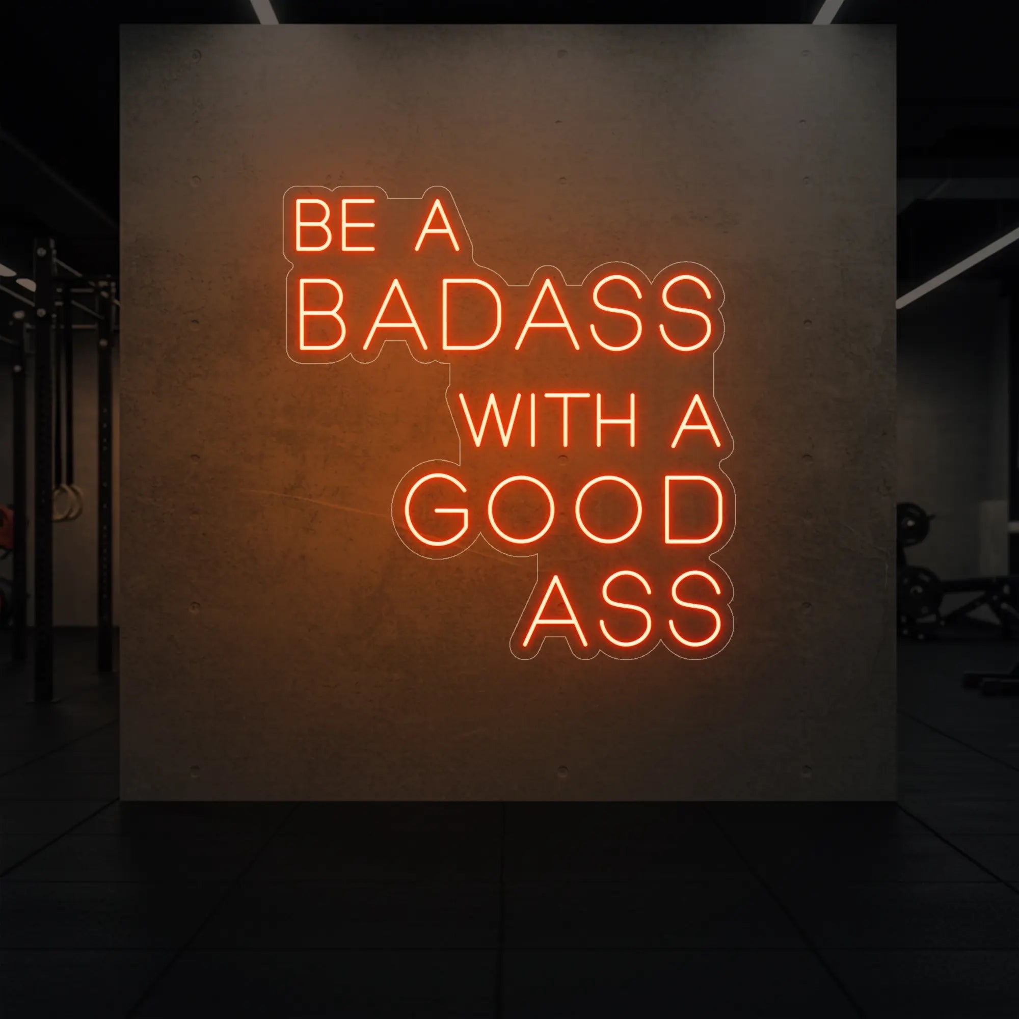  'Be a Badass With a Good Ass' neon sign glowing in golden yellow against a styled interior wall.