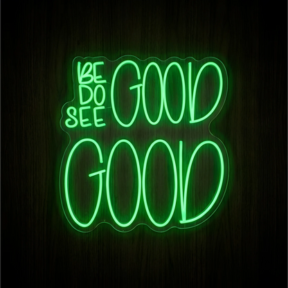 Be Good Do Good See Good LED Neon Sign with small green “BE,” “DO,” and “SEE” lettering beside oversized glowing green “GOOD” words on contoured clear acrylic, displayed against a dark wood background for positive wall decor.