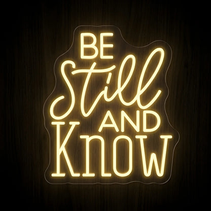 Be Still and Know LED neon sign featuring inspirational Christian typography in warm white on a clear acrylic backing for faith-inspired wall decor.