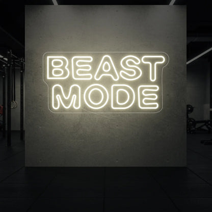 'Beast Mode' neon sign glowing in warm white against a styled interior wall.
