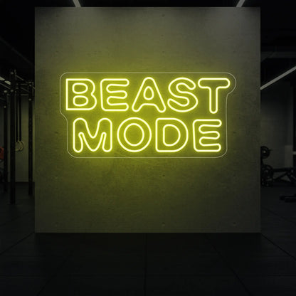  'Beast Mode' neon sign glowing in lemon yellow against a styled interior wall.
