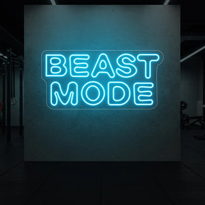  'Beast Mode' neon sign glowing in ice blue against a styled interior wall.