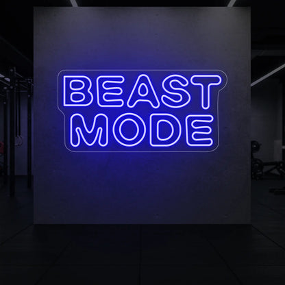 'Beast Mode' neon sign glowing in deep blue against a styled interior wall.