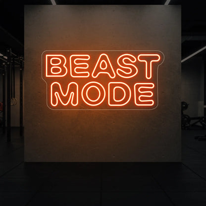 'Beast Mode' neon sign glowing in golden yellow against a styled interior wall.