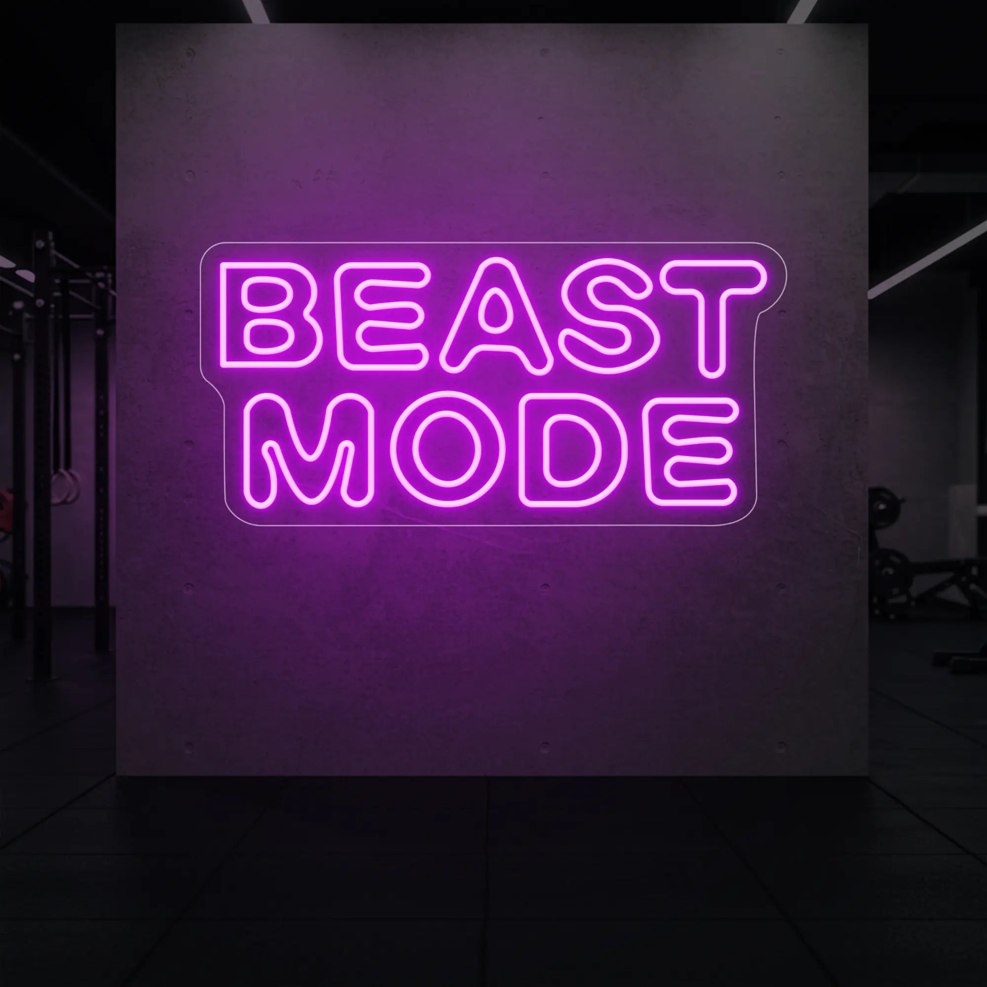  'Beast Mode' neon sign glowing in deep pink against a styled interior wall.