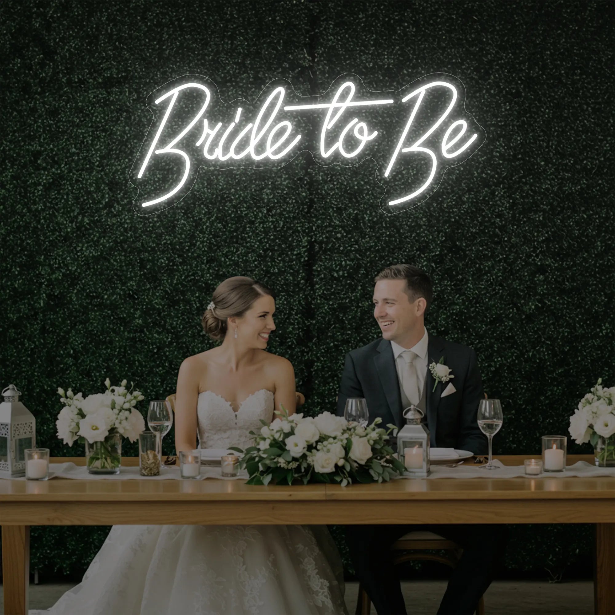 Photo of the 'Bride To Be' neon sign glowing in cool white against a styled interior wall.