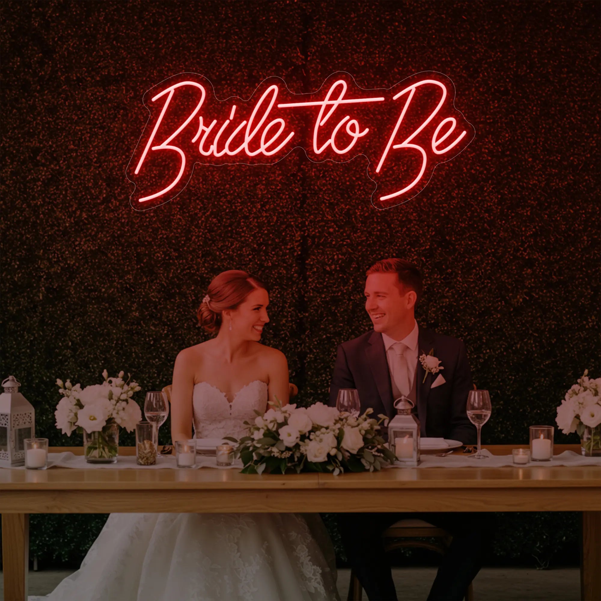 Photo of the 'Bride To Be' neon sign glowing in red against a styled interior wall.