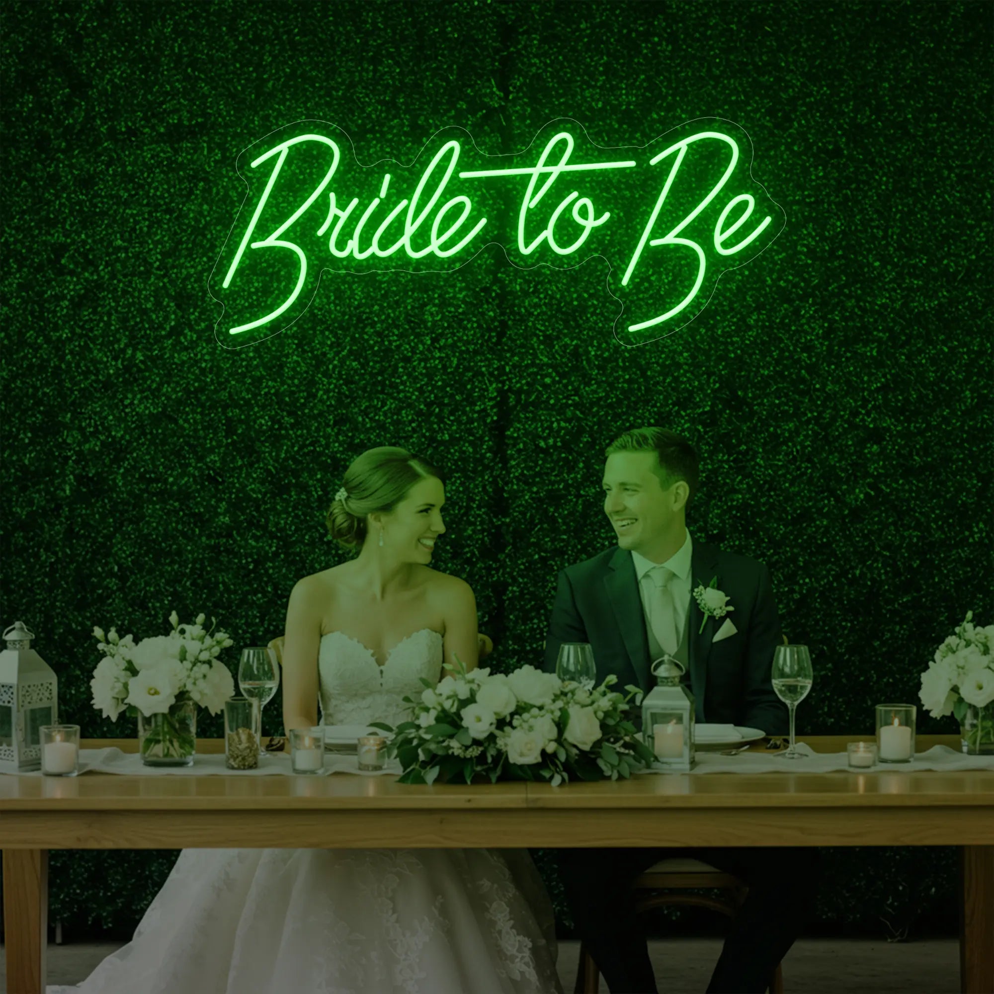 Photo of the 'Bride To Be' neon sign glowing in green against a styled interior wall.