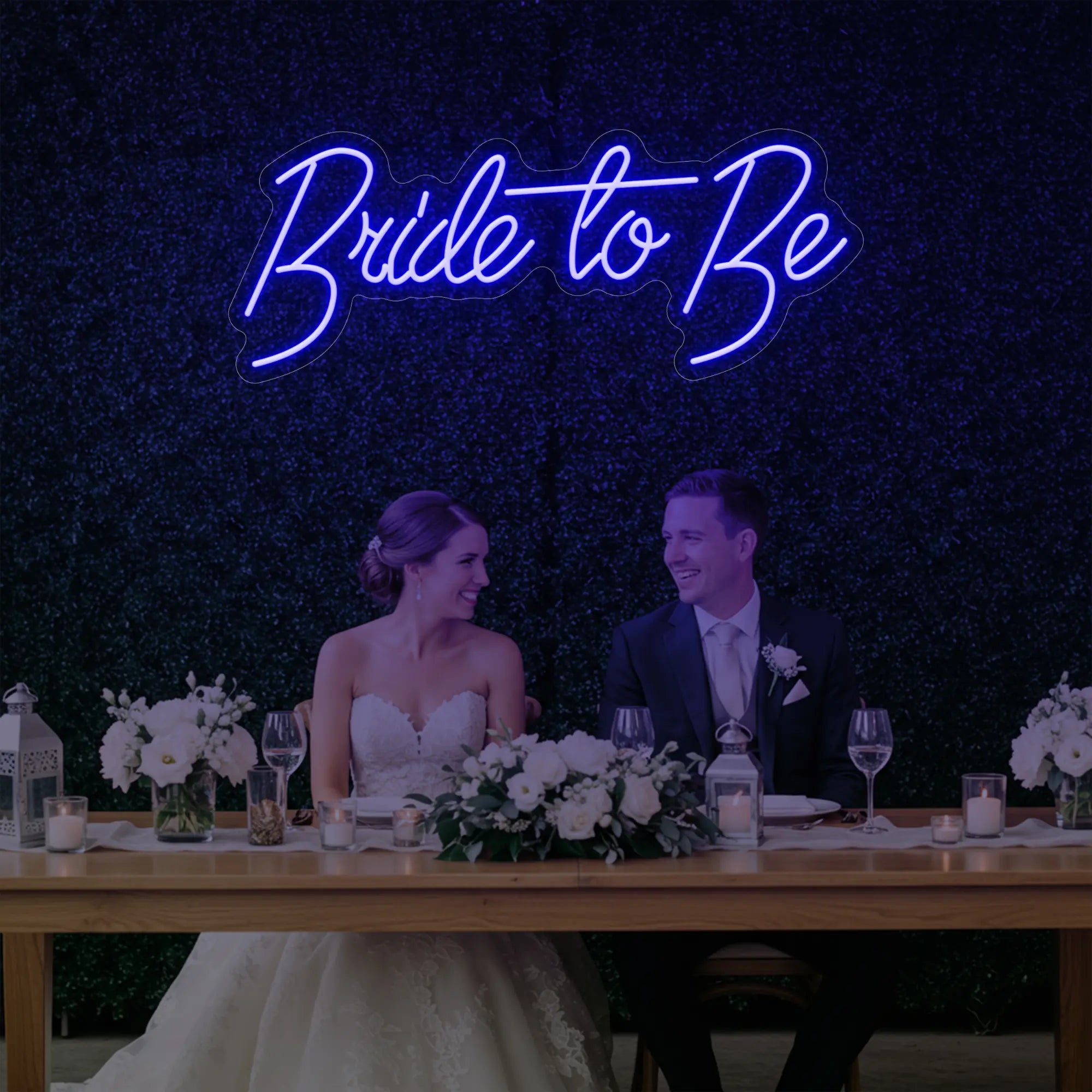 Photo of the 'Bride To Be' neon sign glowing in deep blue against a styled interior wall.