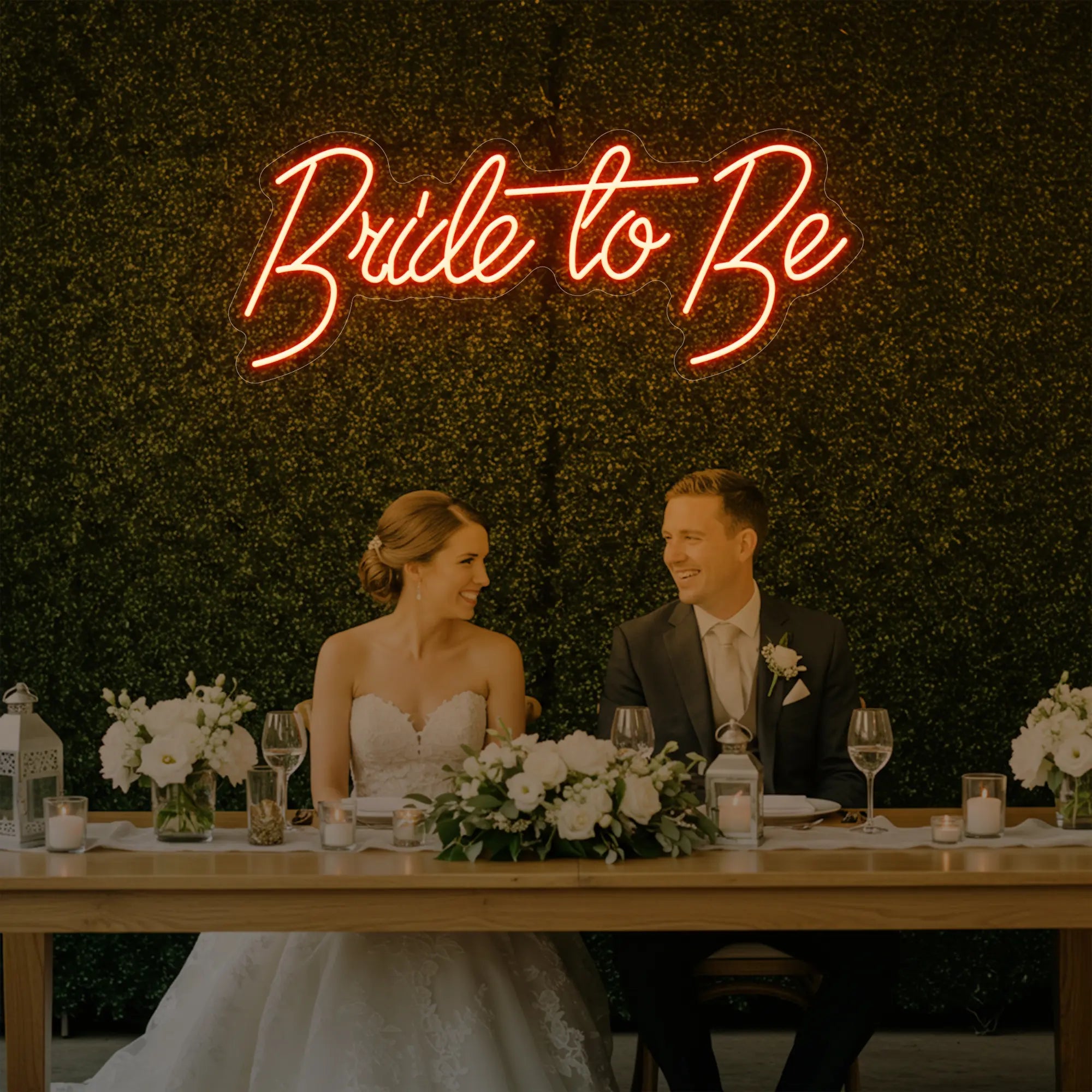 Photo of the 'Bride To Be' neon sign glowing in golden yellow against a styled interior wall.
