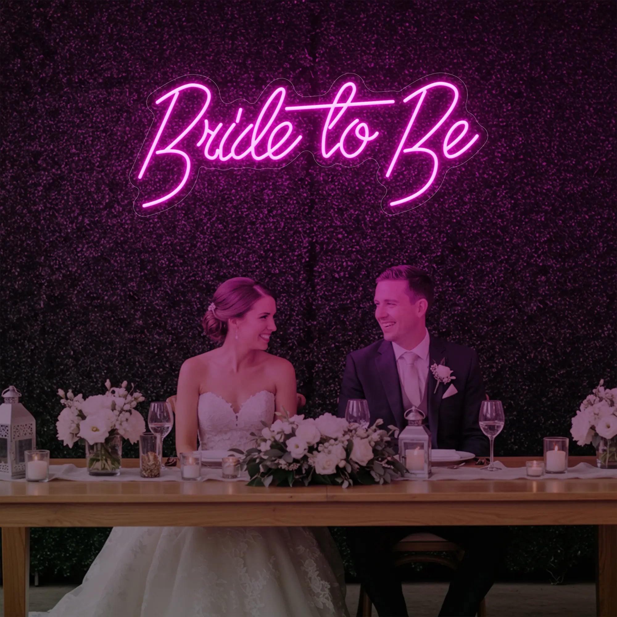 Photo of the 'Bride To Be' neon sign glowing in light pink against a styled interior wall.