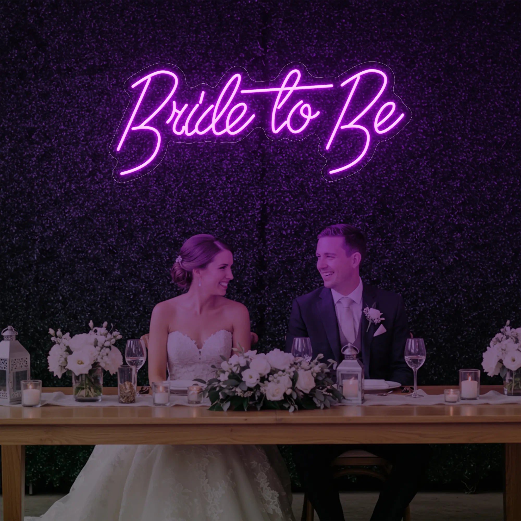 Photo of the 'Bride To Be' neon sign glowing in deep pink against a styled interior wall.