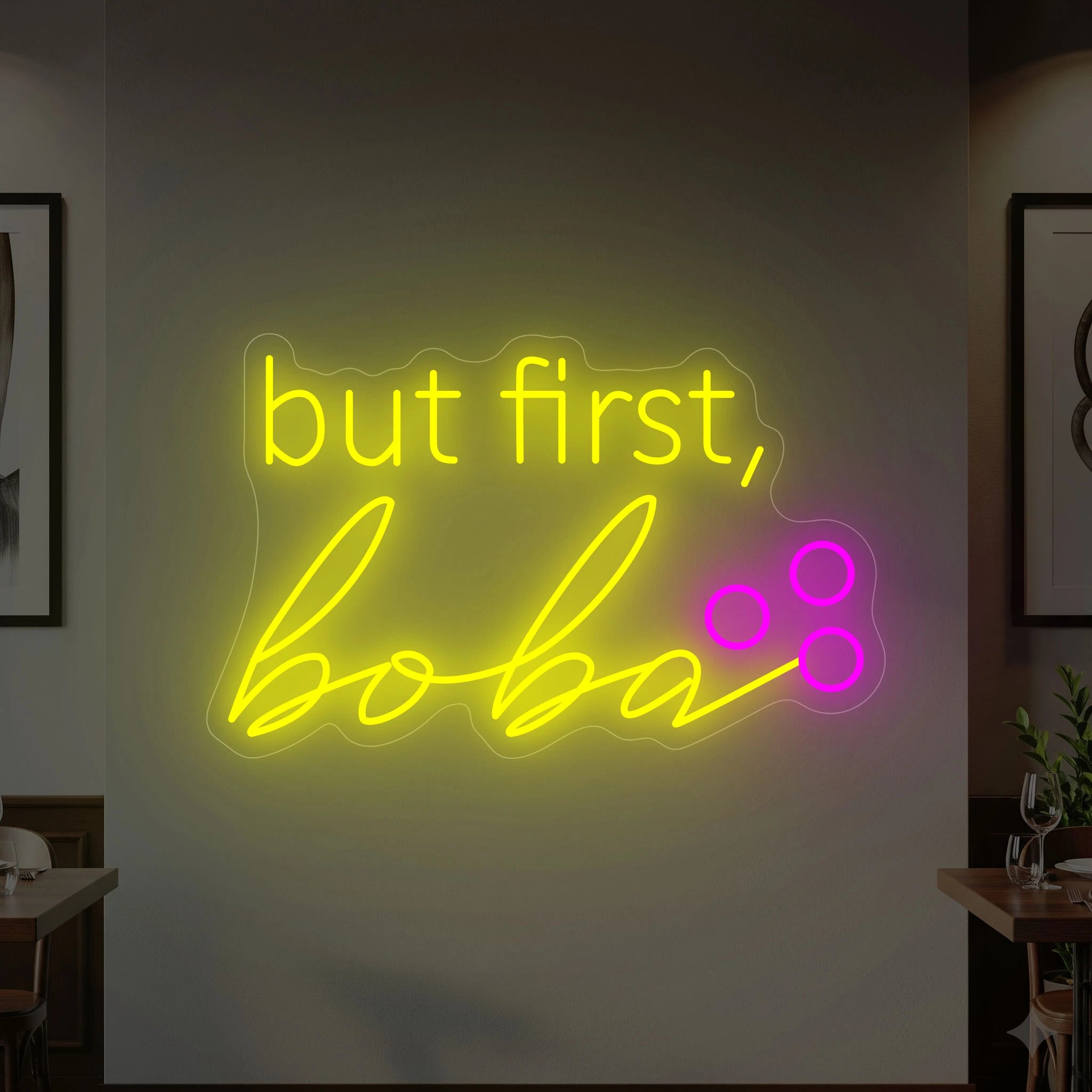 Photo of the 'BUT FIRST, BOBA' neon sign glowing in lemon yellow and deep pink against a styled interior wall.