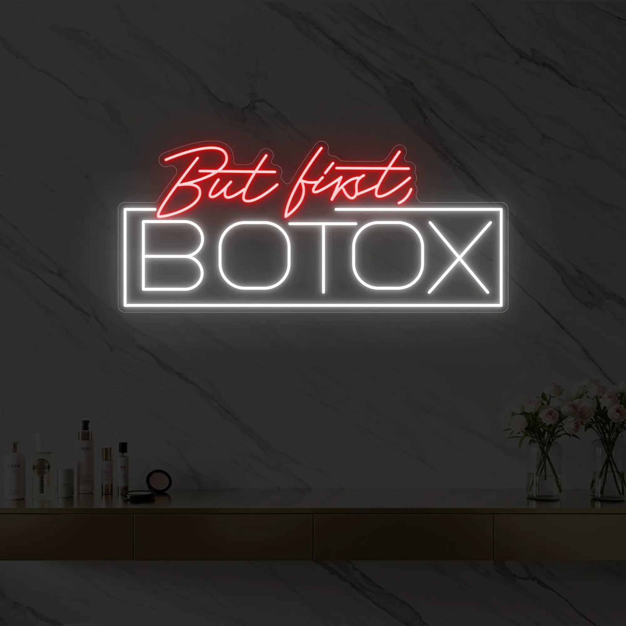 Photo of the 'But first, BOTOX' neon sign glowing in red against a styled interior wall.