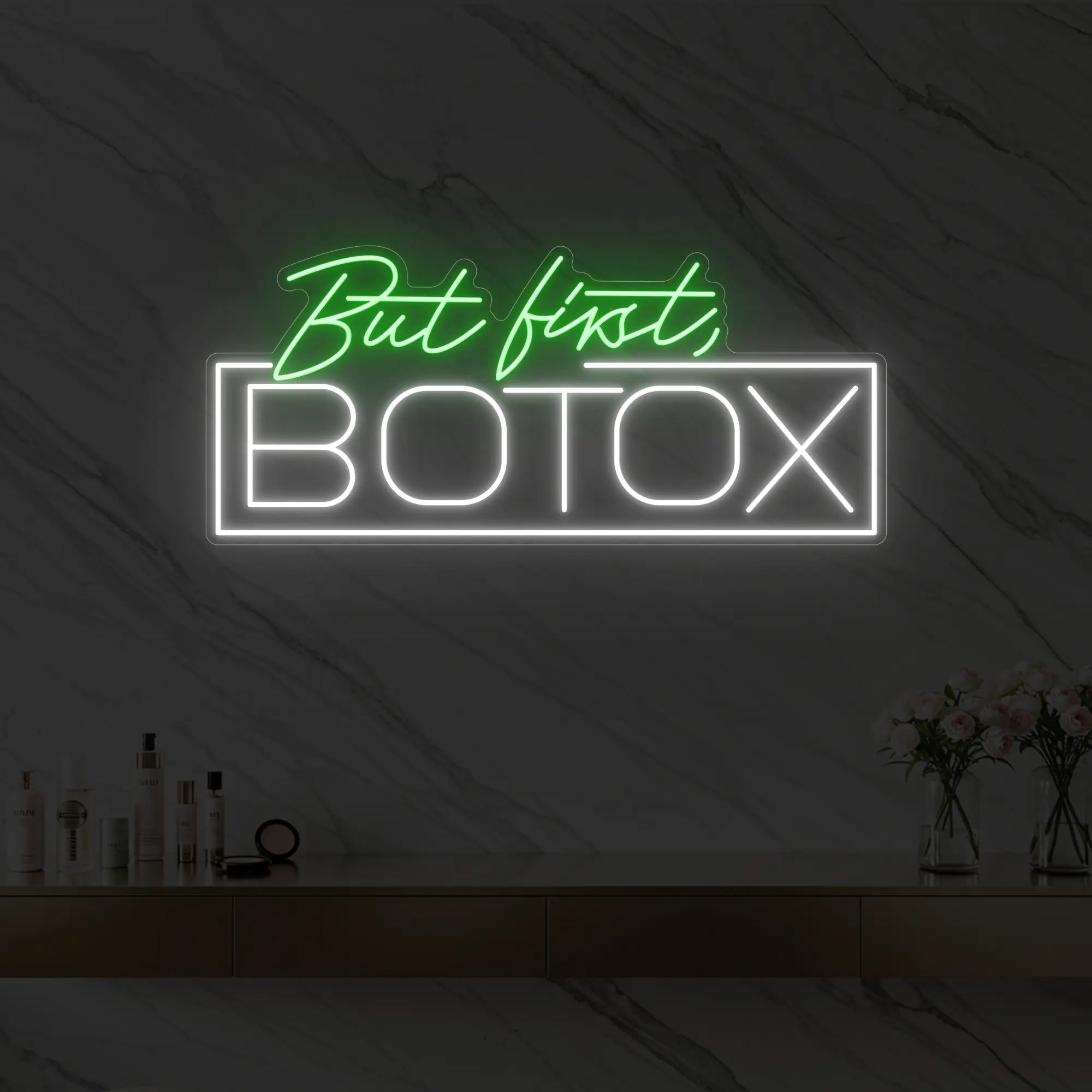 Photo of the 'But first, BOTOX' neon sign glowing in green against a styled interior wall.