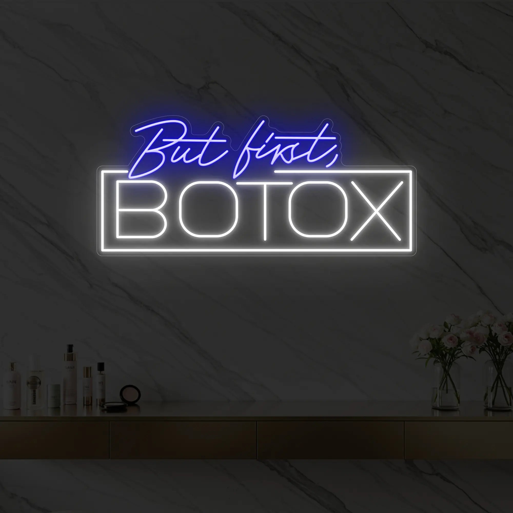 Photo of the 'But first, BOTOX' neon sign glowing in deep blue against a styled interior wall.