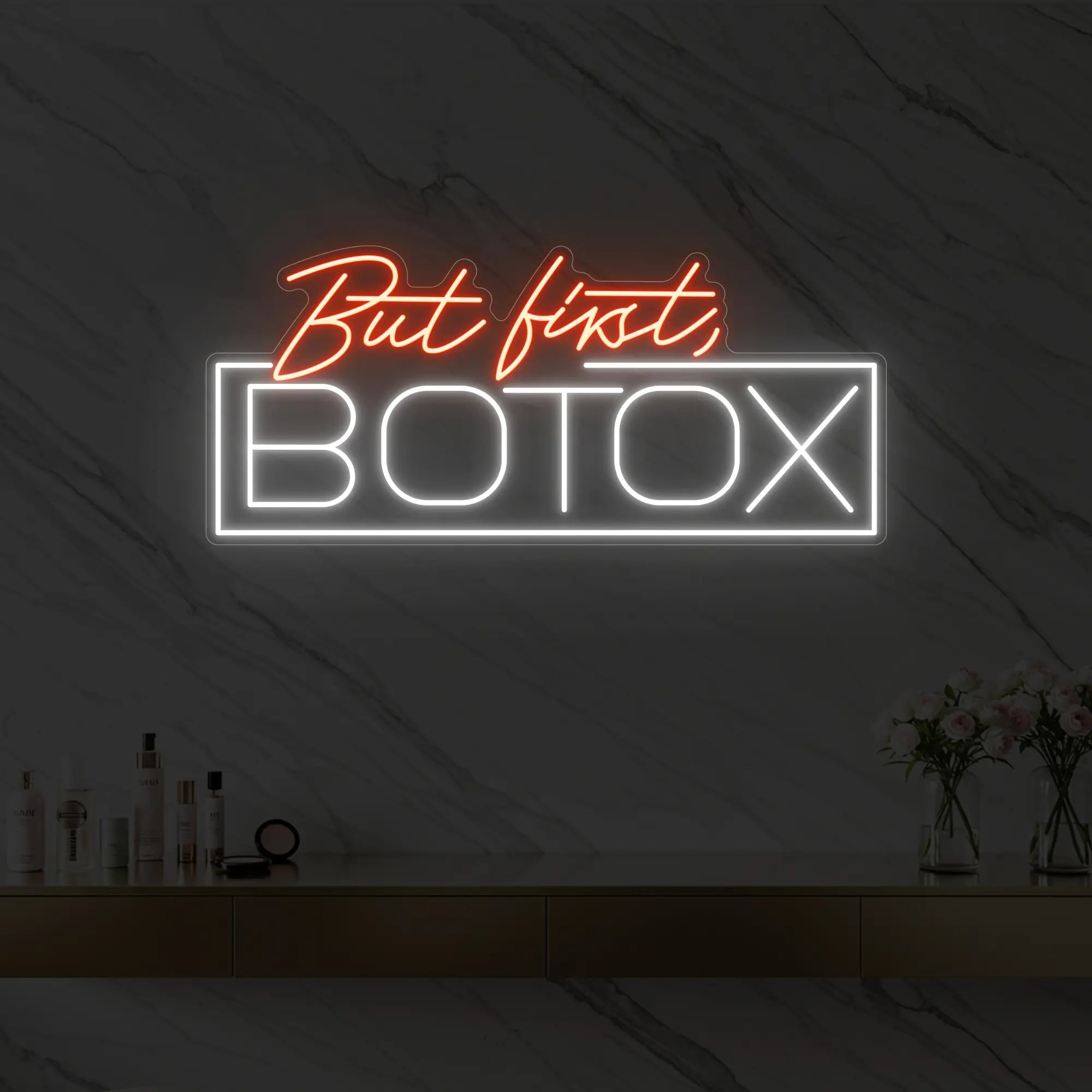 Photo of the 'But first, BOTOX' neon sign glowing in golden yellow against a styled interior wall.