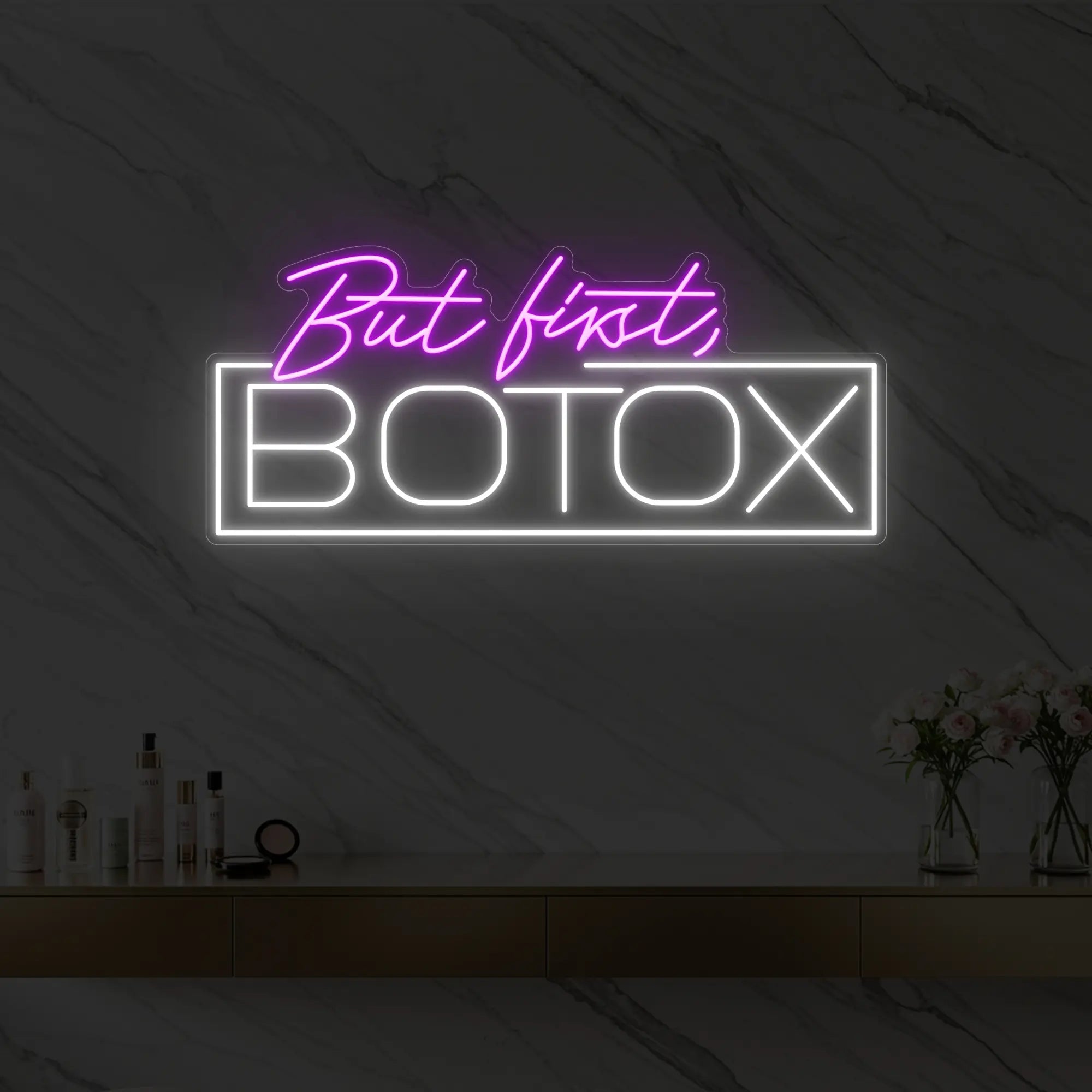 Photo of the 'But first, BOTOX' neon sign glowing in deep pink against a styled interior wall.