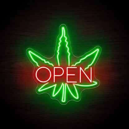 Green cannabis leaf OPEN LED neon sign with red lettering on clear acrylic backing for dispensary and recreational retail wall décor.