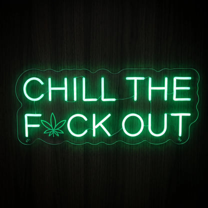 Chill The F*ck Out quote LED neon sign featuring bright green lettering with a cannabis leaf icon on a clear acrylic backing.