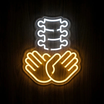 Chiropractic Spine Care LED neon sign featuring a cool white spinal column above two golden-yellow supportive hands on clear acrylic backing for chiropractic clinic wall decor.