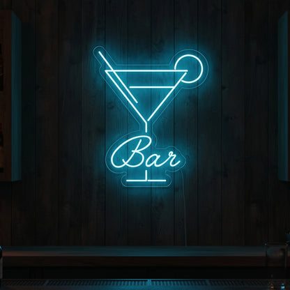 Photo of the 'BAR' neon sign glowing in ice blue against a styled interior wall.