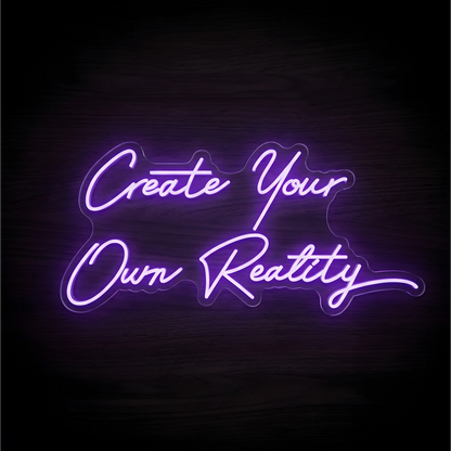 “Create Your Own Reality” LED Neon Sign in glowing purple script lettering on clear acrylic against a dark wood background, ideal for bedrooms, home offices, and creative studios.