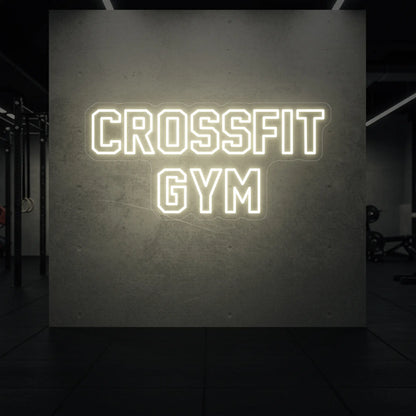  'CrossFit Gym' neon sign glowing in warm white against a styled interior wall.