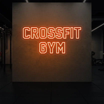  'CrossFit Gym' neon sign glowing in golden yellow against a styled interior wall.