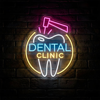 Dental Clinic Tooth Treatment LED neon sign featuring a white tooth outline, pink dental instrument, blue and yellow Dental Clinic lettering, and golden circular accents on clear acrylic backing against a dark brick wall.