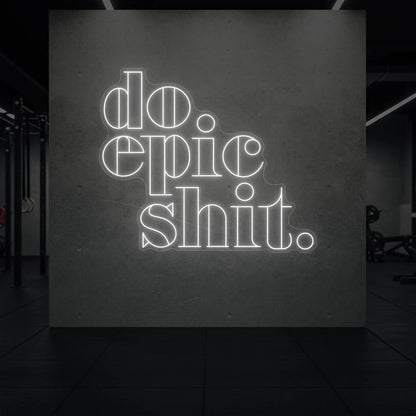  'Do Epic Shit.' neon sign glowing in cool white against a styled interior wall.