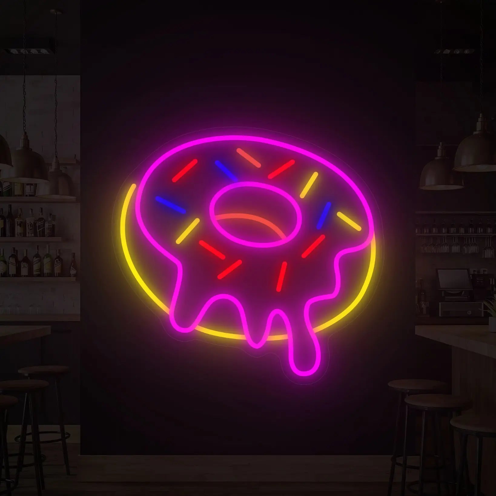 Photo of the 'DONUT' neon sign glowing in multi-color against a styled interior wall.