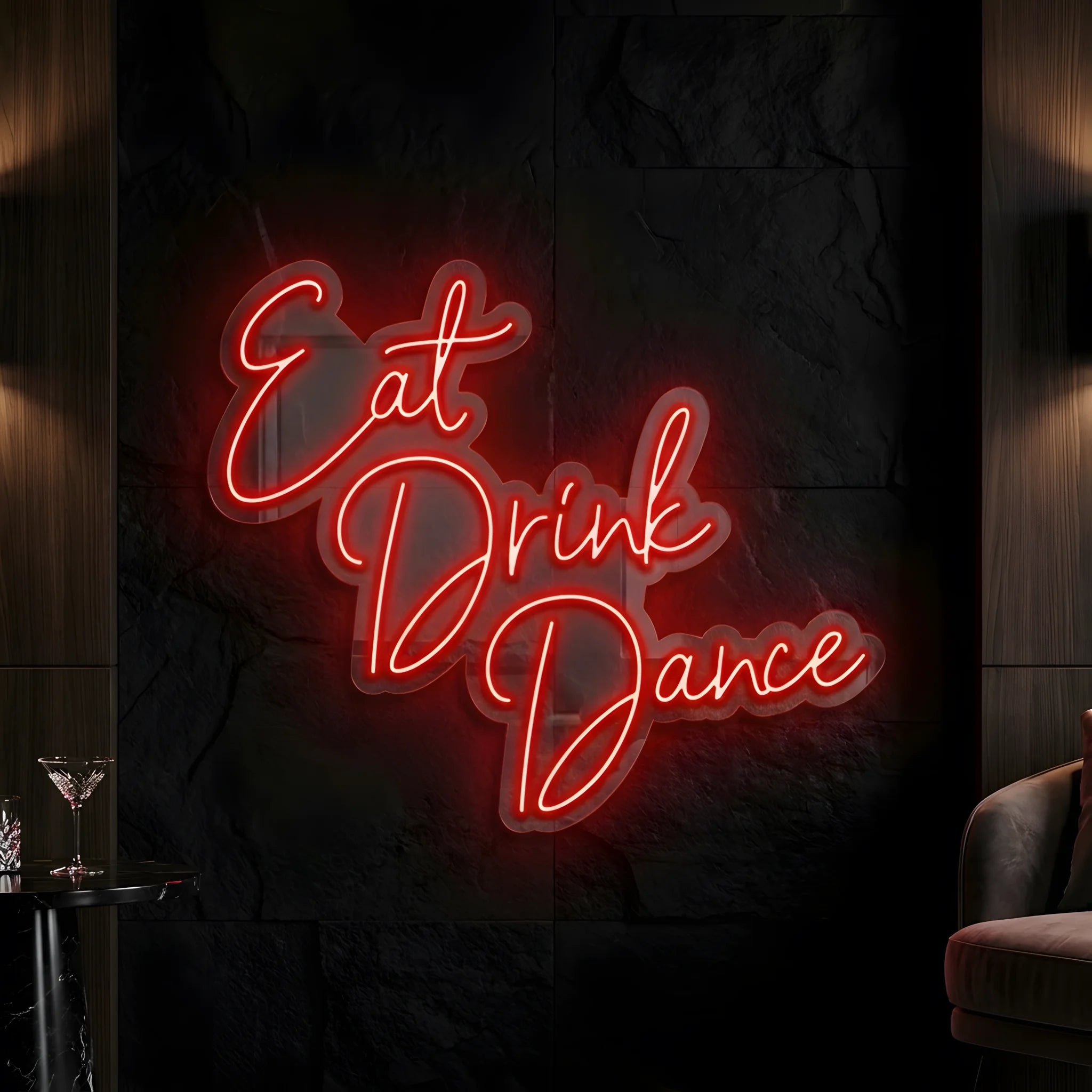 Photo of the 'Eat Drink Dance' neon sign glowing in red against a styled interior wall.
