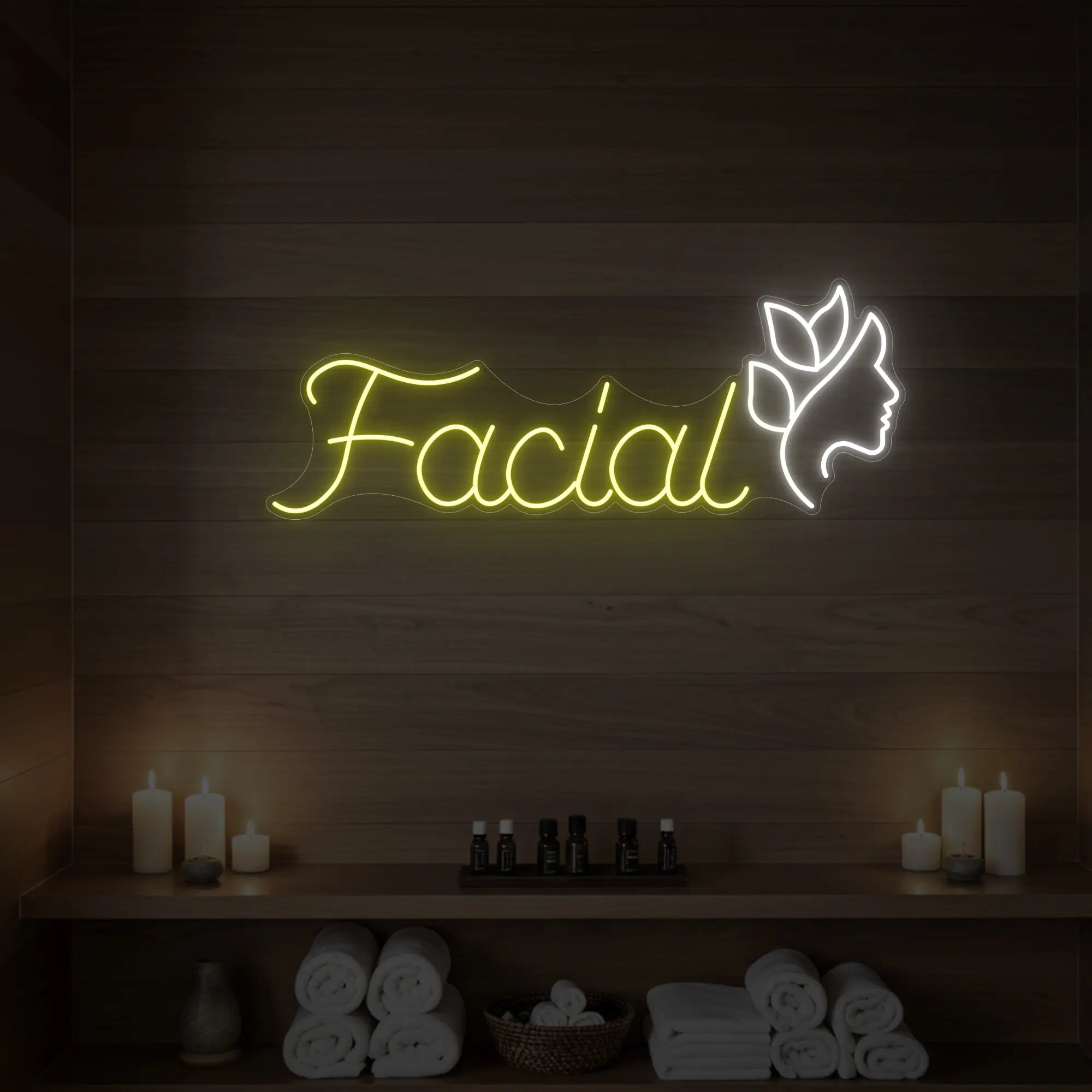 Photo of the 'Facial' neon sign with a botanical face silhouette glowing in lemon yellow against a styled interior wall.